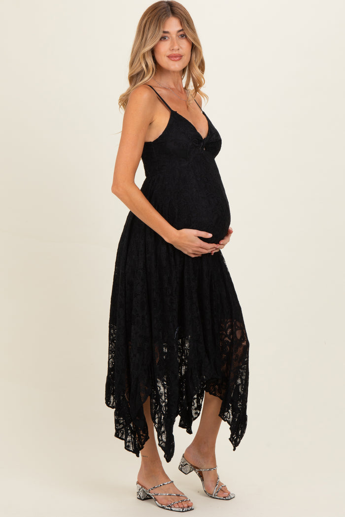 woman wearing a black lace maternity dress with an asymmetrical hemline and holding her baby bump