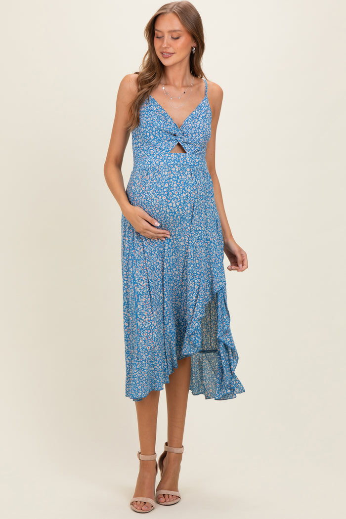 woman wearing a blue floral maternity dress with a knot detail, showing her baby bump and a flowing hemline