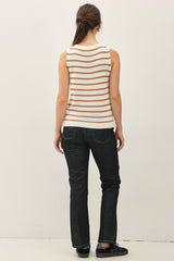 woman wearing a white and orange striped sleeveless top and black jeans, viewed from the back