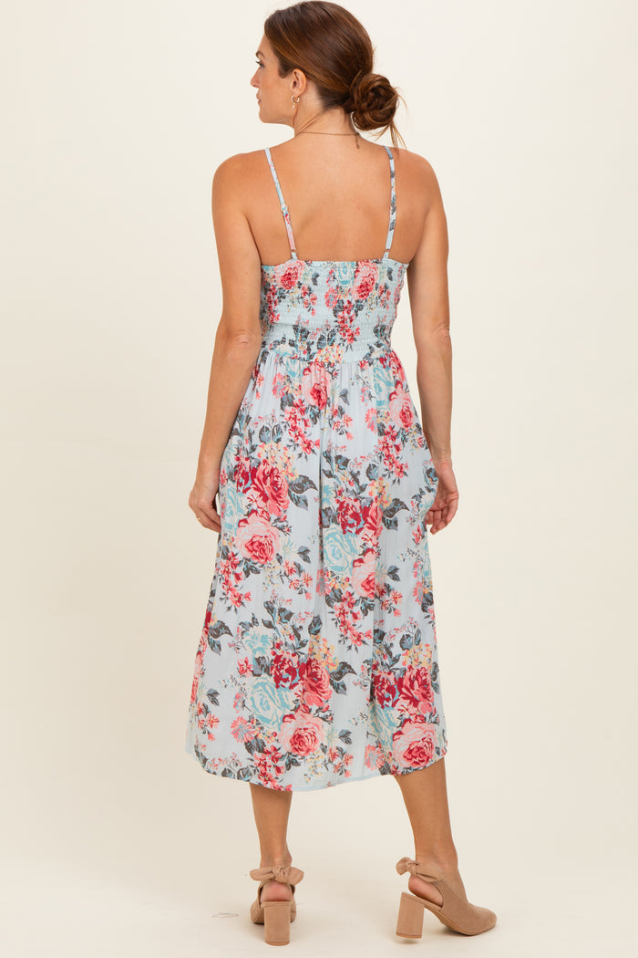 woman wearing a blue floral midi dress with a smocked back and thin straps