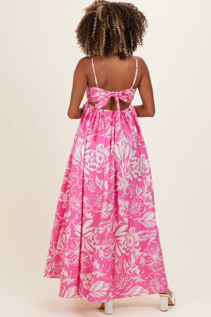 woman wearing a pink floral maternity maxi dress with a bow back detail