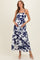 woman wearing a blue and white floral maternity maxi dress and gently cradling her baby bump