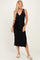 woman wearing a black sleeveless wrap dress with a tie at the waist and side slits, smiling at the camera