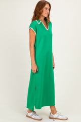 woman wearing a bright green maxi dress with a v-neck and collar, styled with white sneakers