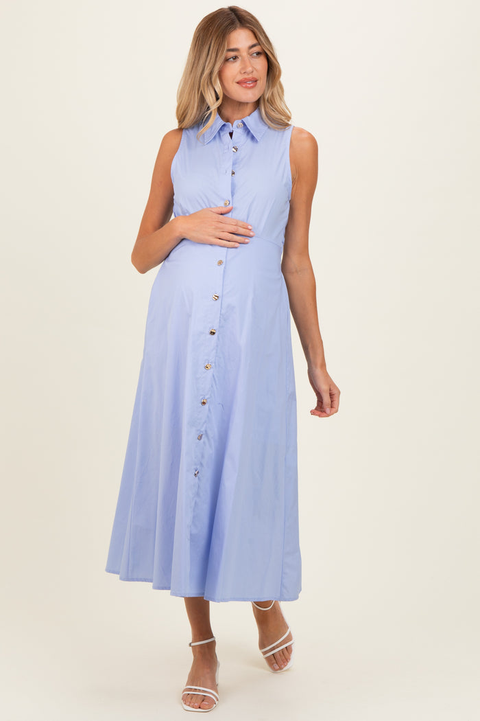 woman wearing a light blue sleeveless maternity dress with button details and holding her baby bump