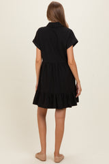 woman wearing a black maternity dress with short sleeves and a ruffled hem