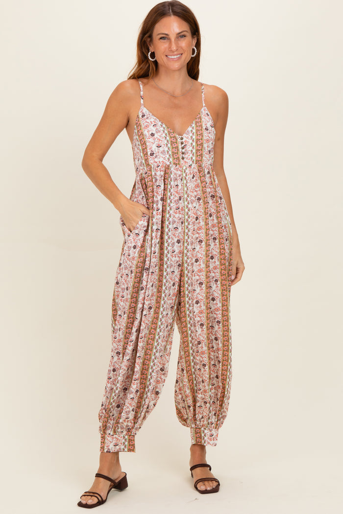 woman wearing a floral print sleeveless jumpsuit with pockets and comfortable fit, styled with brown sandals