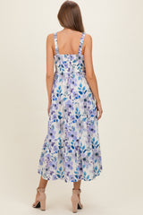 woman wearing a floral print maxi maternity dress with ruffled straps and a tiered skirt, showing a baby bump