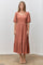 woman wearing a rust-colored midi dress with puff sleeves and a square neckline