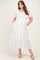 woman wearing a white maternity plus dress with red floral print and puff sleeves, showing her baby bump and pockets