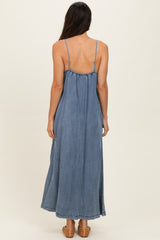 woman wearing a backless denim maxi dress with thin straps and a flowing silhouette