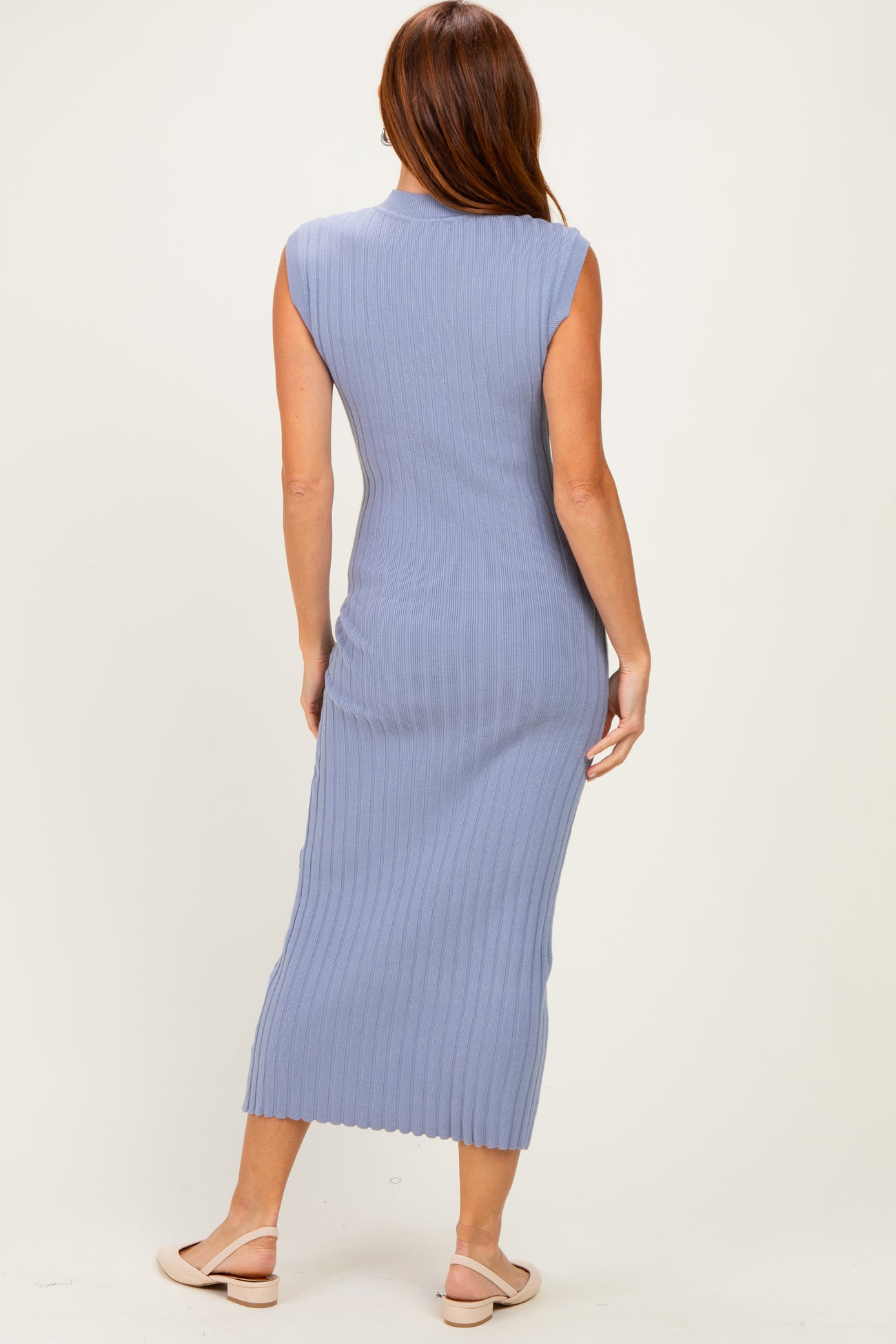 woman wearing a light blue ribbed midi dress, sleeveless style, seen from the back