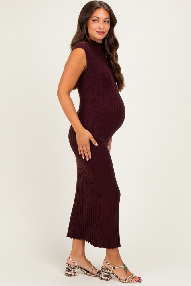 woman wearing a burgundy ribbed maternity dress, showcasing her baby bump, paired with stylish sandals