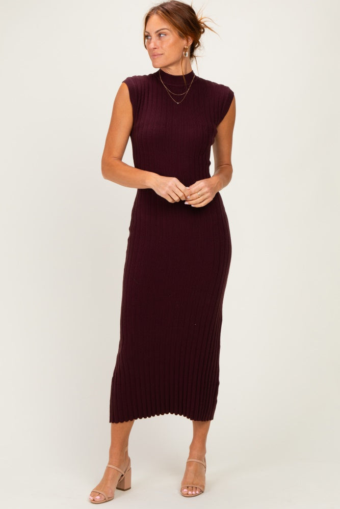 woman wearing a dark burgundy sleeveless ribbed midi dress with a mock neck and side slit