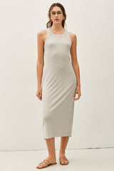 woman wearing a light gray ribbed tank dress that falls below the knee, paired with flat sandals and glasses