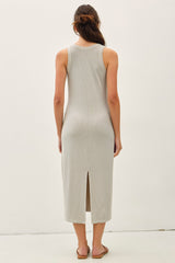 woman wearing a light gray sleeveless maxi dress with a back slit and open back