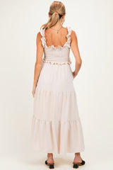 woman wearing a soft pink maternity maxi dress with ruffled straps and a smocked bodice, showcasing a flowing skirt