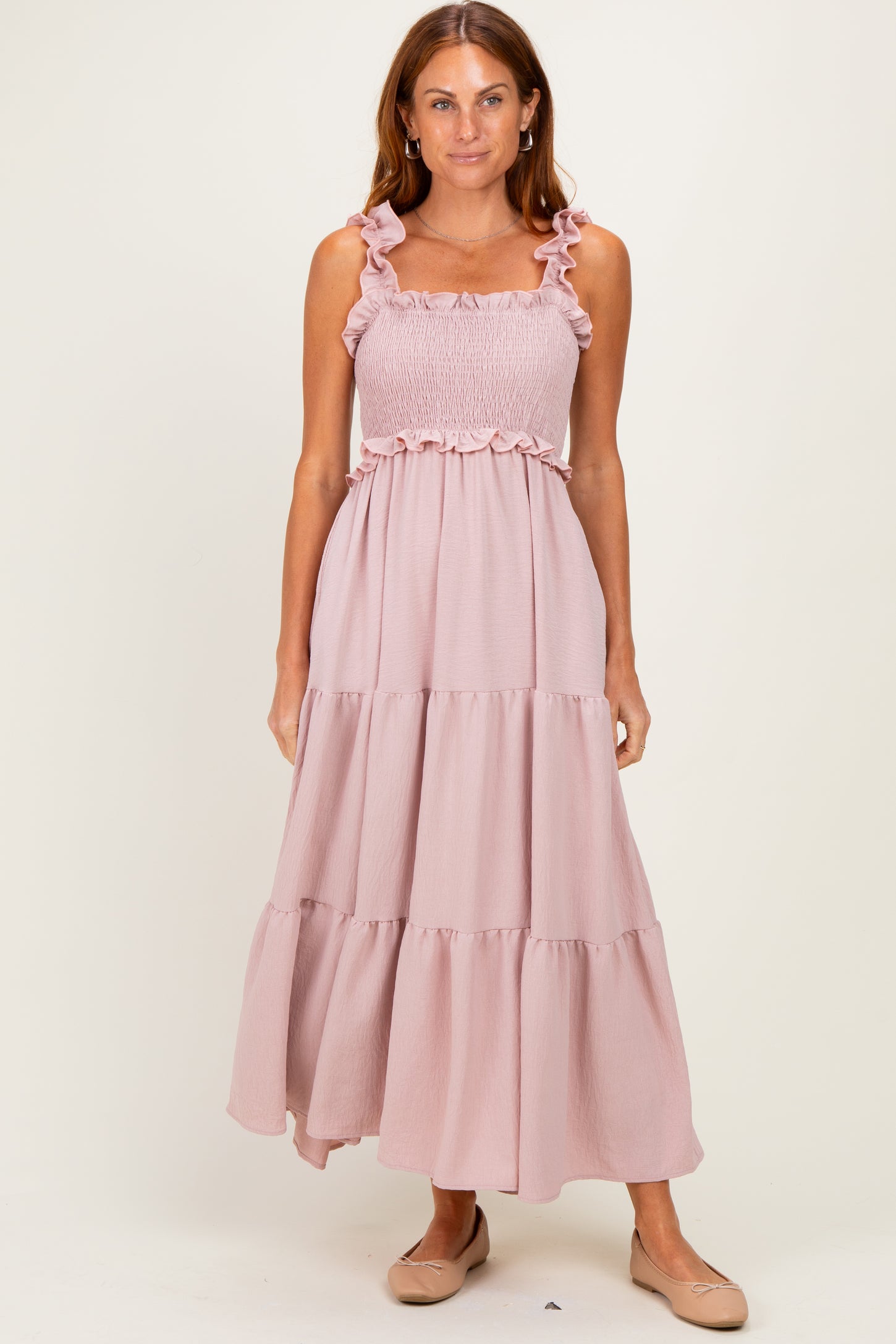woman wearing a pink maxi dress with ruffled straps and a smocked bodice