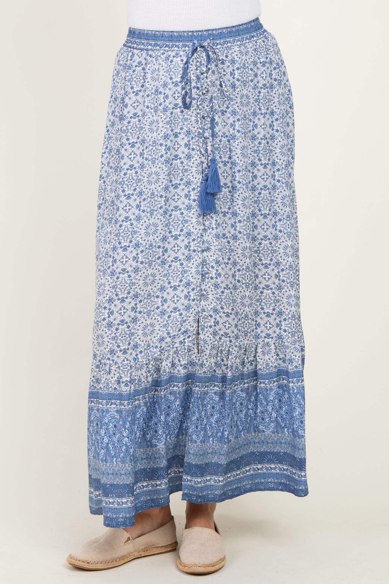woman wearing a blue patterned maxi skirt with a drawstring waist and tassel details