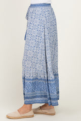 woman wearing a blue floral maxi skirt with a tiered design and drawstring waist, paired with light footwear