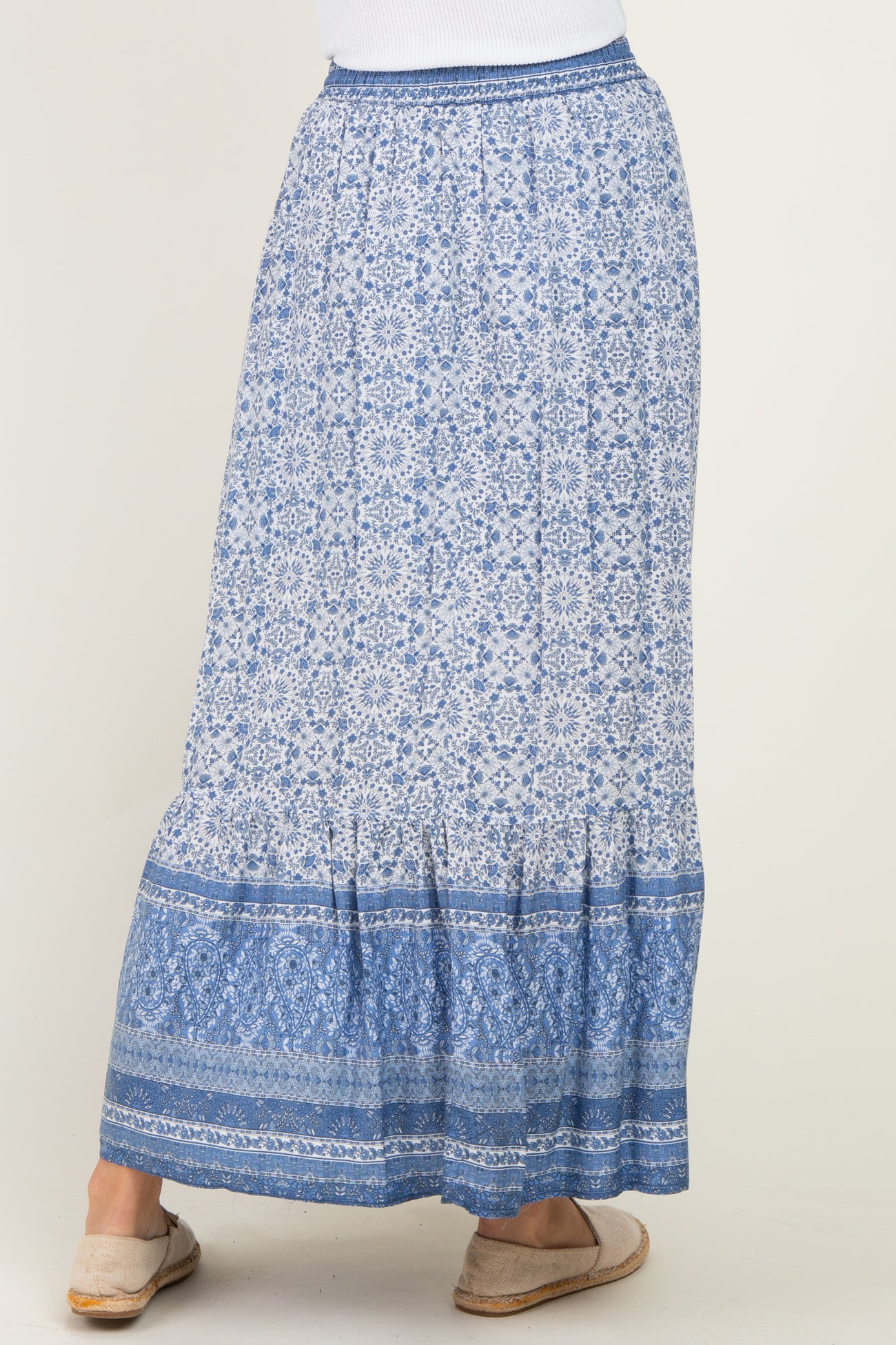 woman wearing a blue patterned maxi skirt with a tiered hem and elastic waistband