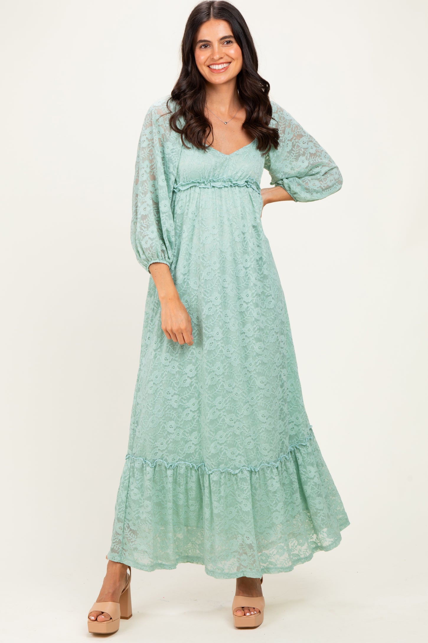 woman wearing a light green lace maxi dress with puff sleeves and a ruffled hem