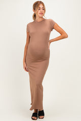 woman wearing a tan pregnant bodycon maxi dress showing her baby bump and paired with black heels