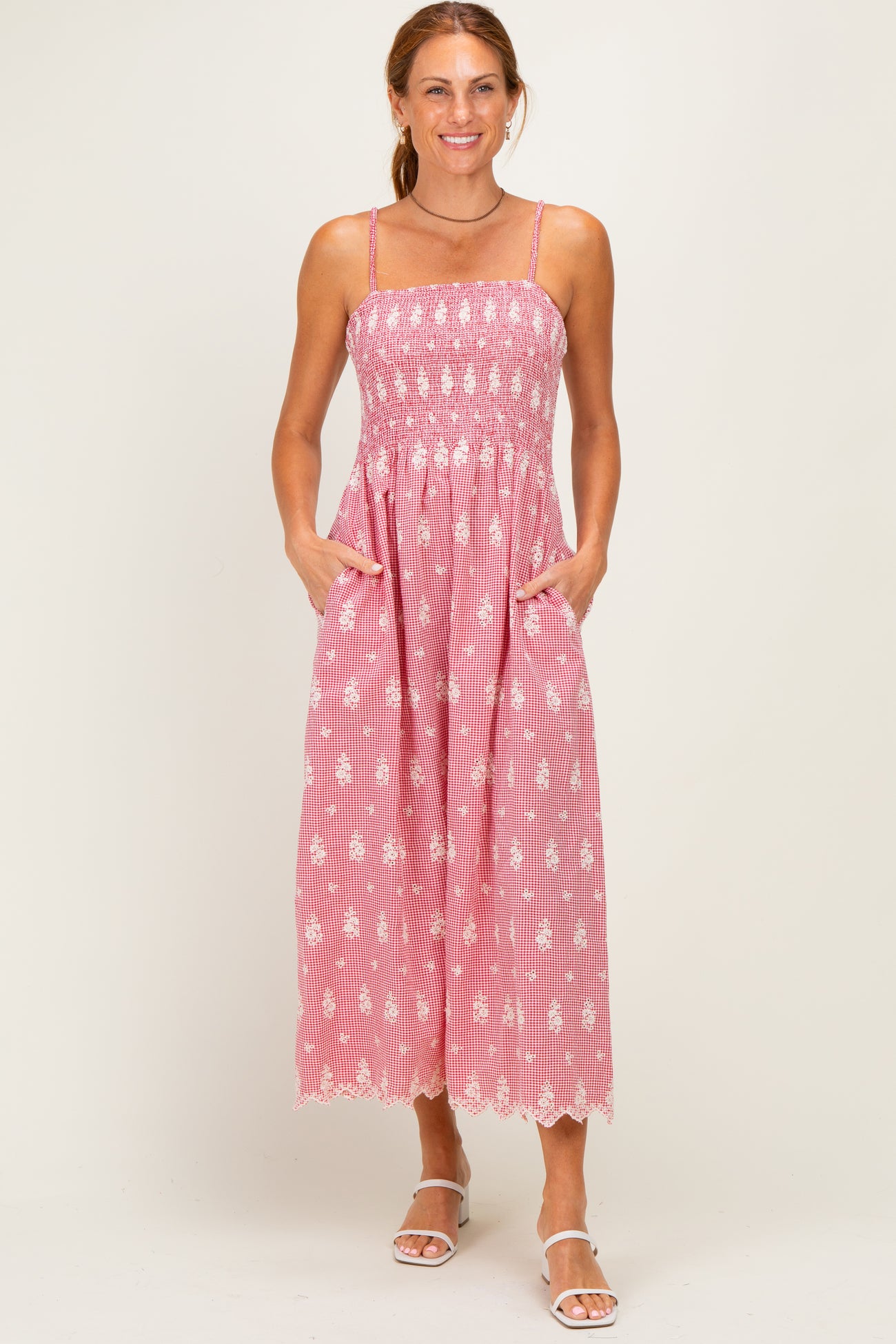 woman wearing a pink and white striped maxi dress with a smocked bodice and pockets