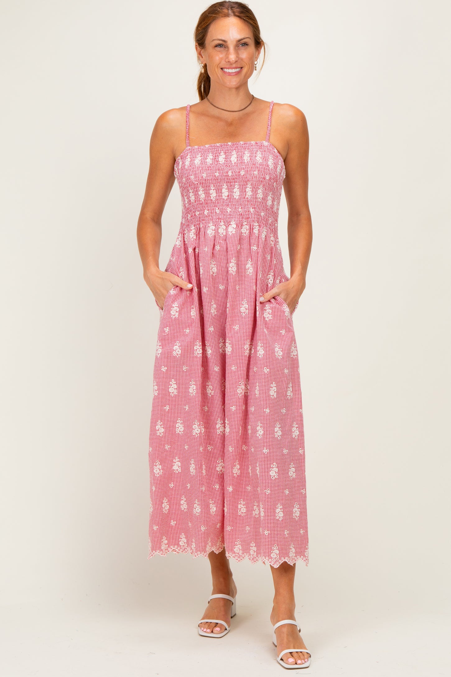 woman wearing a pink and white striped maxi dress with a smocked bodice and pockets