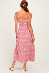 woman wearing a pink and white floral maxi dress with a smocked back and lace hem, standing with her back to the camera