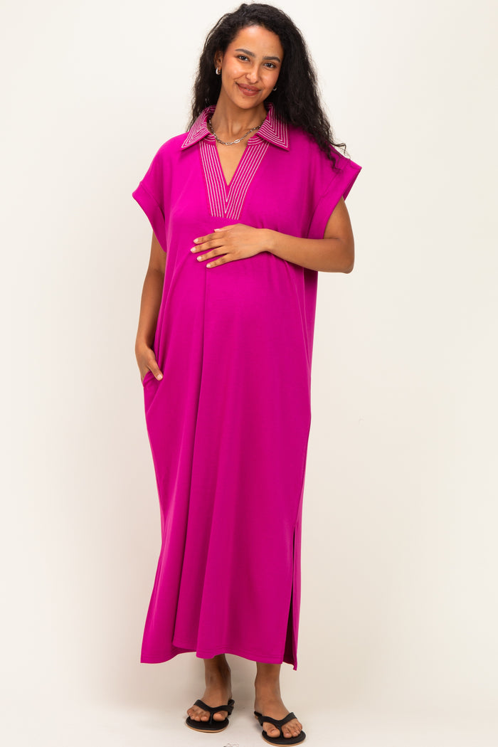 woman wearing a bright pink maternity dress with a striped collar and pockets, showing her baby bump