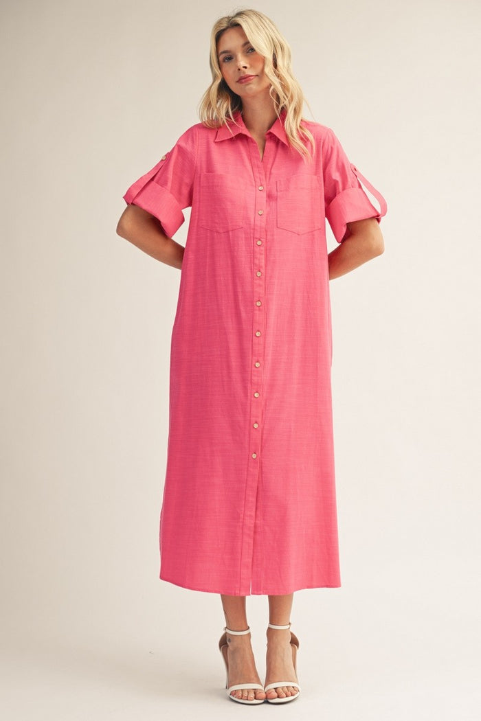woman wearing a bright pink midi shirt dress with button-down front and rolled short sleeves