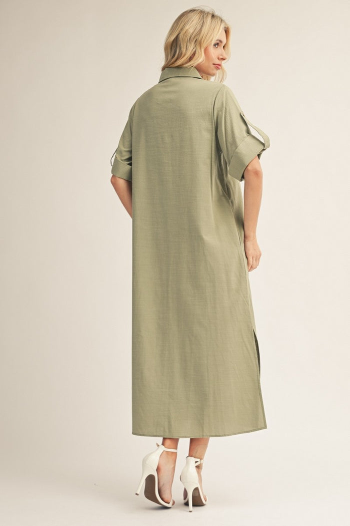 woman wearing an olive green maxi shirt dress with rolled sleeves and side slits, shown from the back with high heels