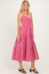 woman wearing a pink and white gingham midi dress with spaghetti straps and a tiered skirt