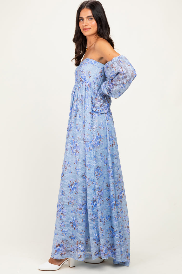 woman wearing a light blue off-the-shoulder maxi dress with floral print and puff sleeves