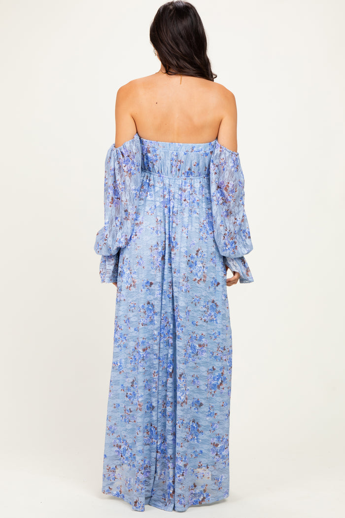 woman wearing a light blue off-the-shoulder maxi dress with long puff sleeves and floral patterns