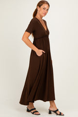 woman wearing a brown short sleeve maxi dress with a v-neck and pockets