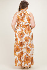 woman wearing a floral print maternity maxi dress with a halter neck and cinched waist, showing the back view