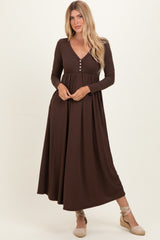 woman wearing a brown ribbed long sleeve maxi dress with a v-neck and button detailing