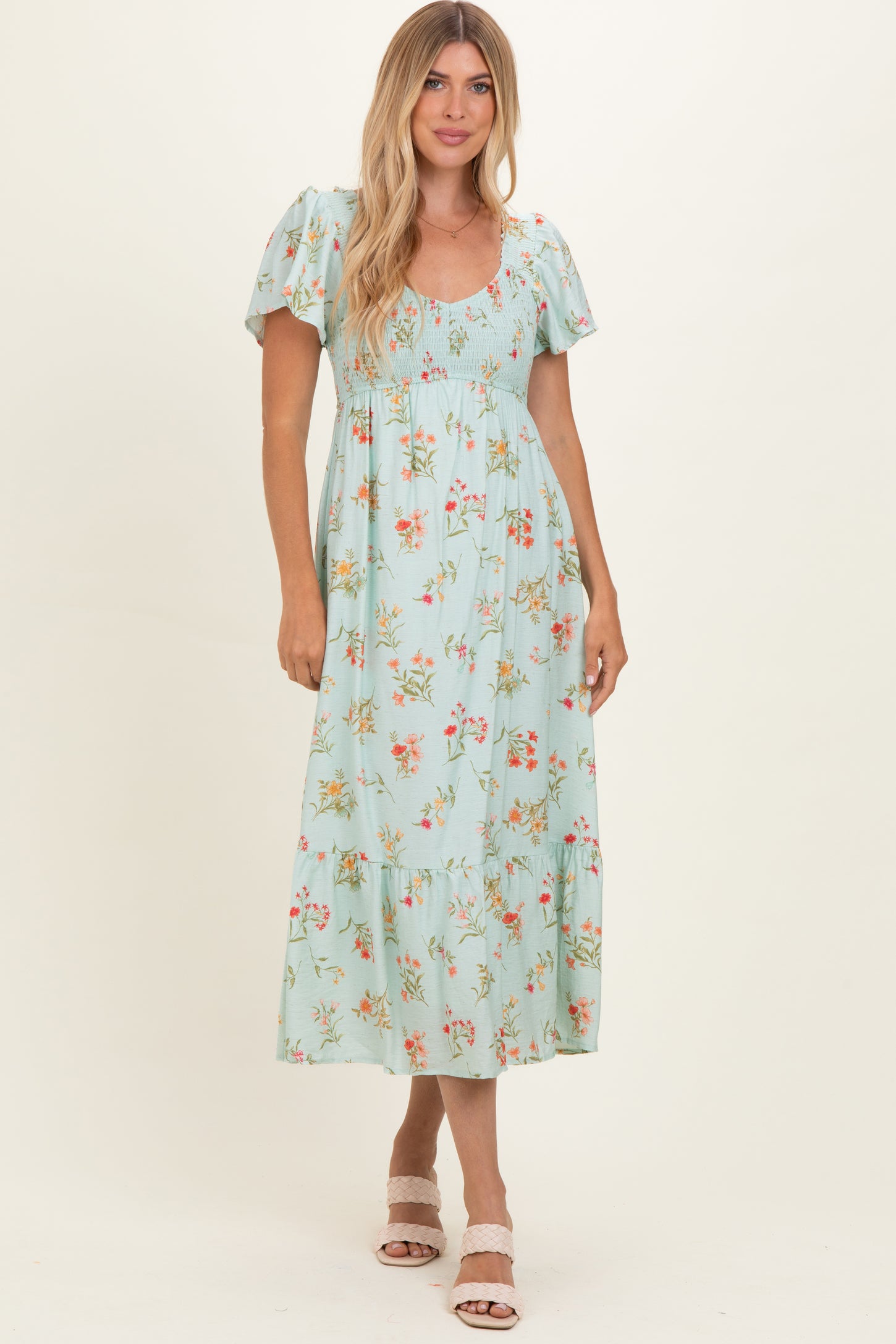 woman wearing a light blue floral maxi dress with puff sleeves and a tiered skirt
