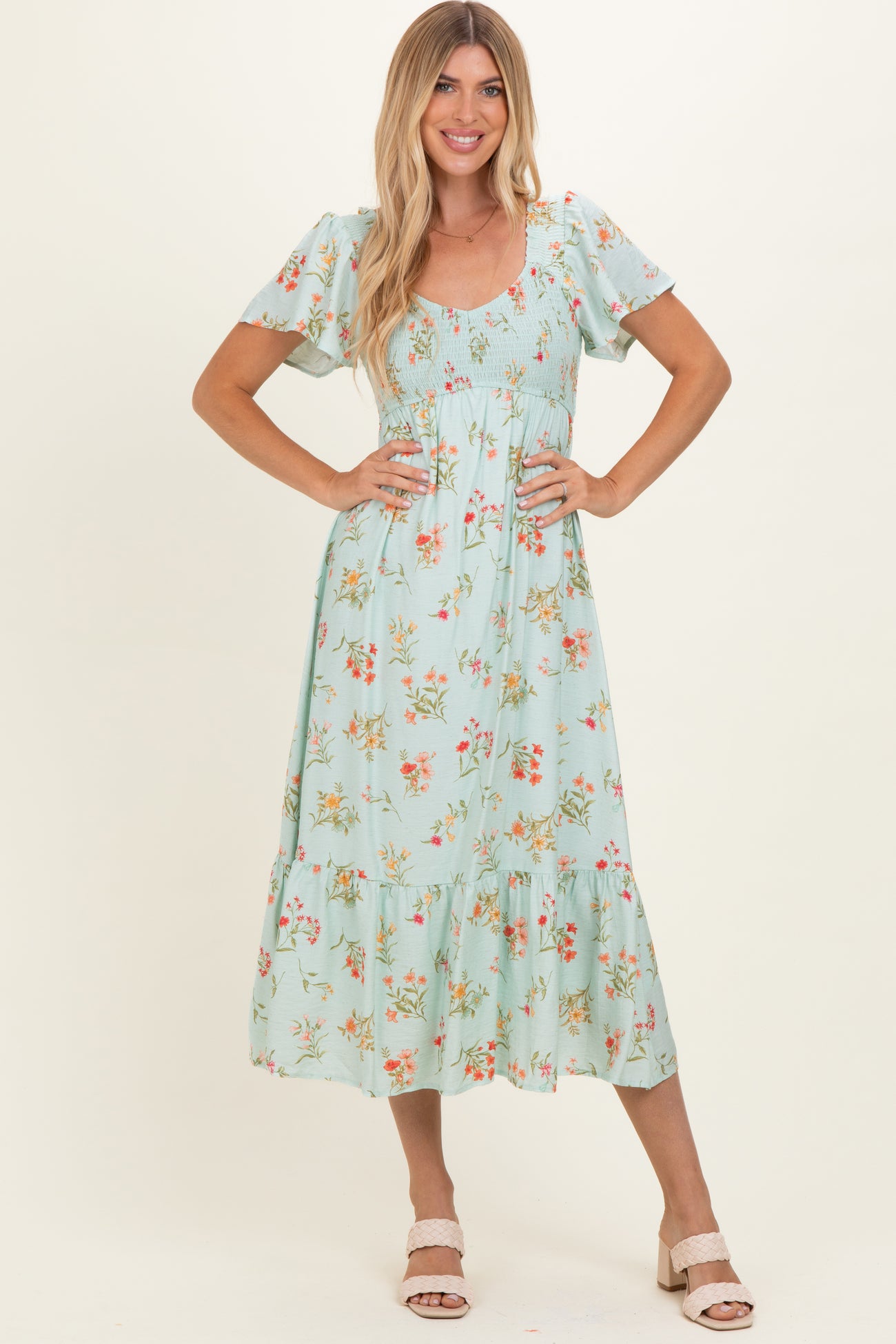 woman wearing a mint green floral maxi dress with short sleeves and a smocked bodice