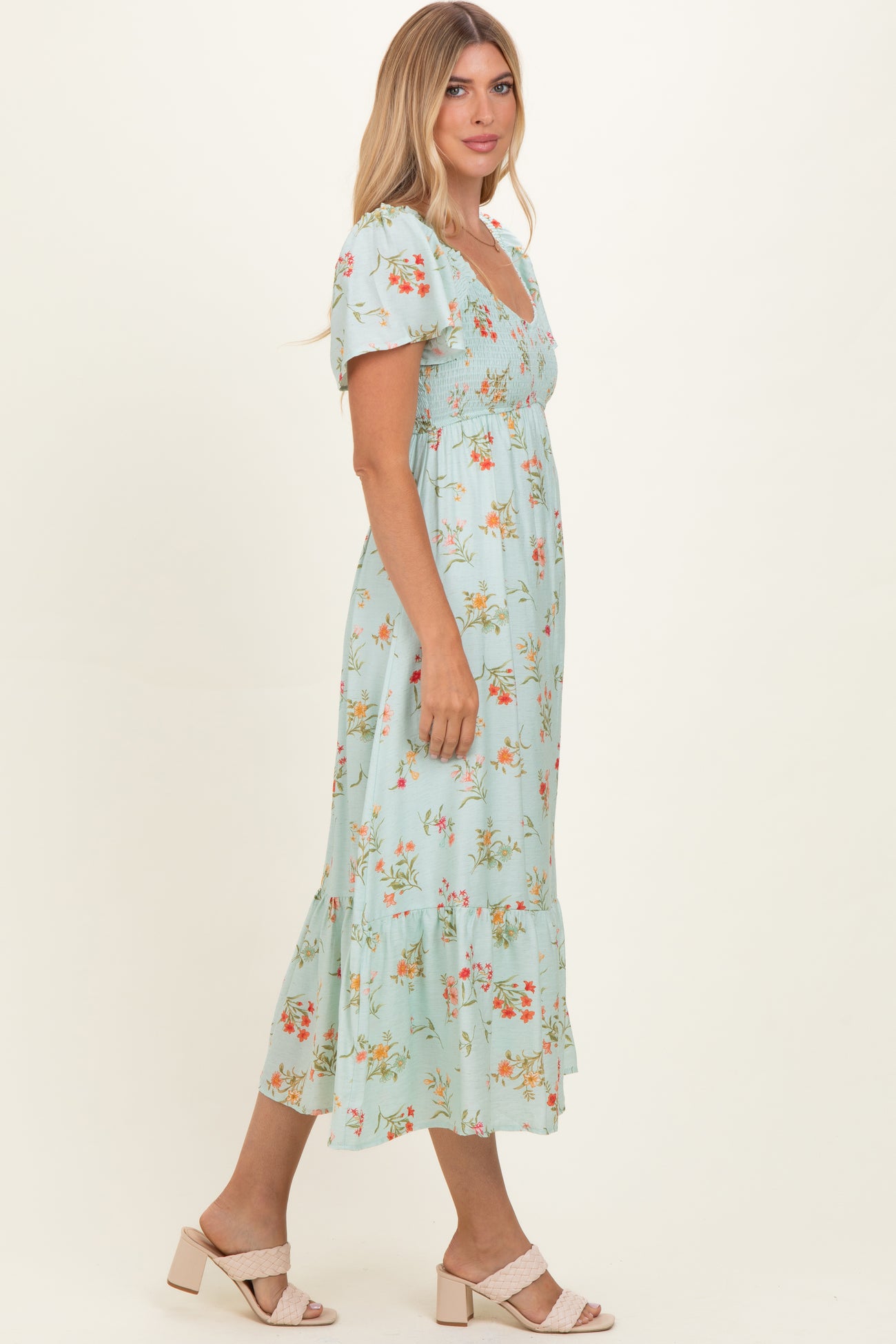woman wearing a light blue floral midi dress with puff sleeves and tiered skirt