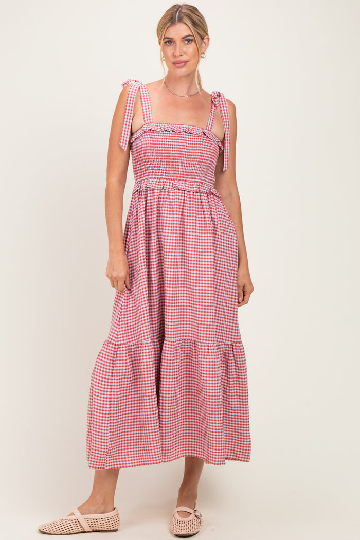 woman wearing a pink and white gingham maxi dress with tie straps and ruffled hem