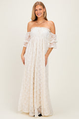 woman wearing an off-the-shoulder white lace maxi dress with puff sleeves and a gathered bodice