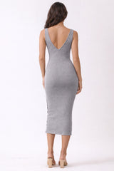 woman wearing a form-fitting gray ribbed midi dress with a deep V back and a slit on the side