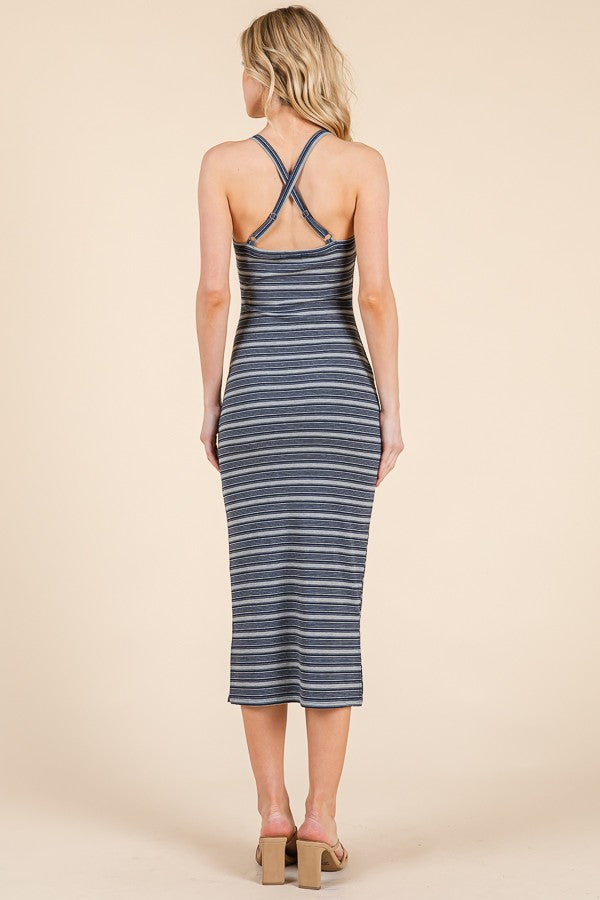 woman wearing a blue and white striped midi dress with crisscross back straps and a fitted silhouette