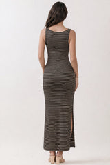 woman wearing a black and tan striped maxi dress with a side slit and a fitted silhouette, seen from the back