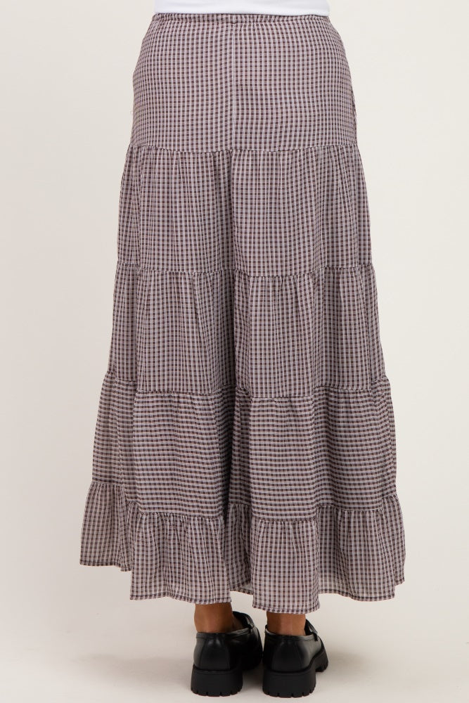 woman wearing a maternity midi skirt with a tiered design in a checkered pattern and a ruffled hem