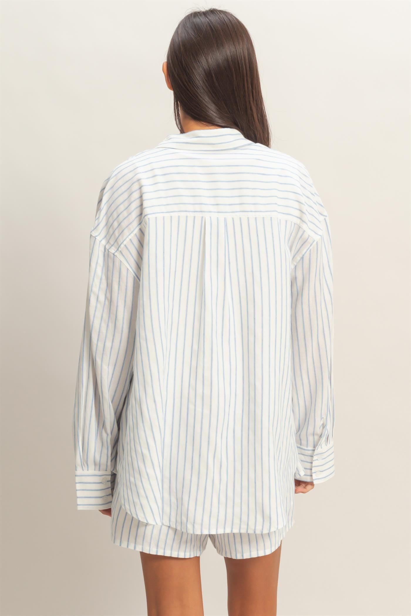 woman wearing a white and light blue striped oversized shirt, viewed from the back