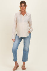 woman wearing a striped maternity button-up shirt and blue maternity jeans, highlighting her baby bump